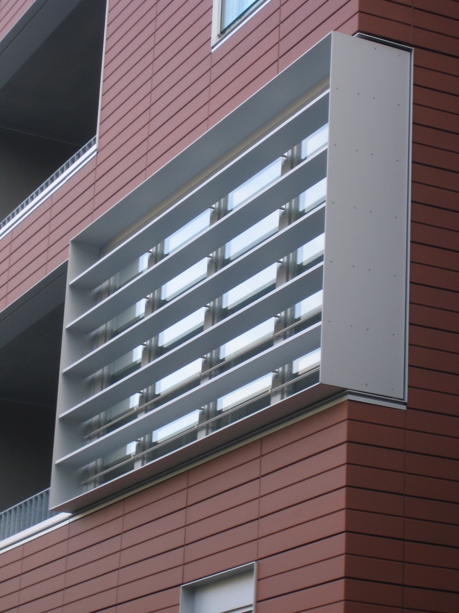 Seitenfassade eines Wohnungsbauprojekts im Innenhafen Duisburg mit roten Keramikpaneelen und einem modernen Fensterdesign