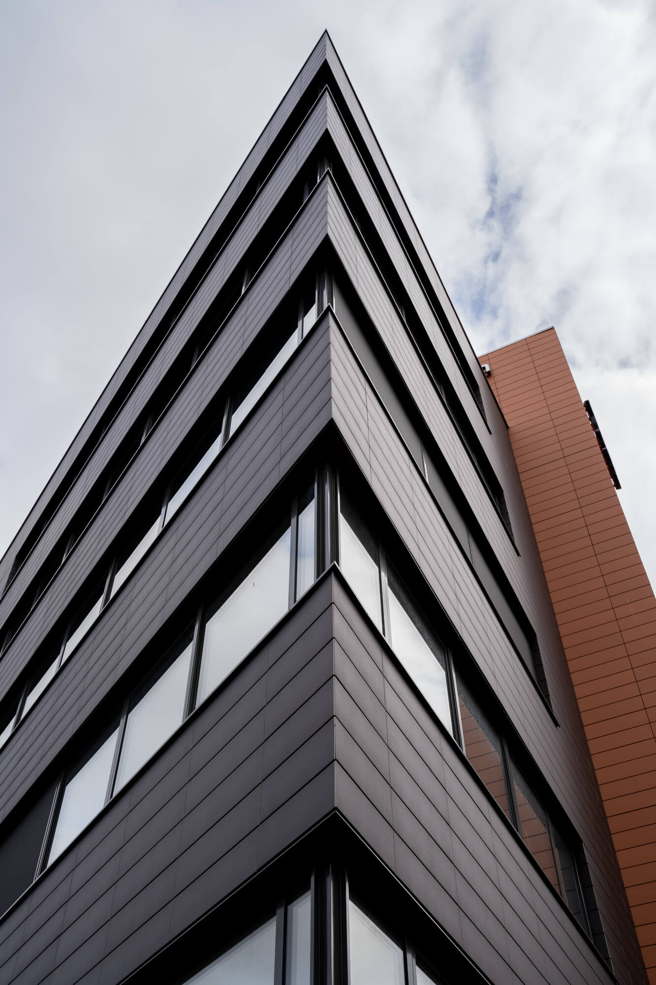 "Close-up view of the corner of the Tonality ceramic facade at the Human Total Care building in Eindhoven, designed by MH1 Architects for ESC Dronten, showcasing excellent craftsmanship and design