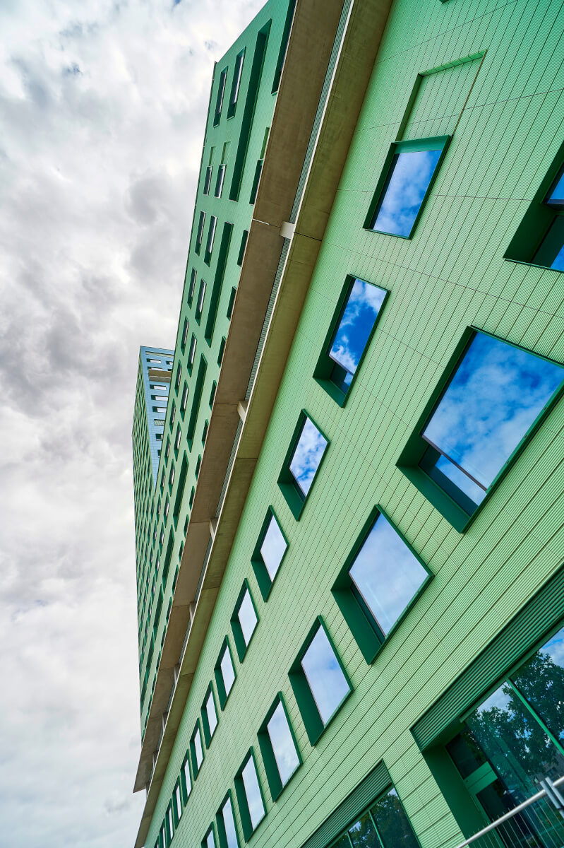 Close-up view of the terracotta tile facade of Cadix Clinic in Antwerpen, showing the tonality and texture of the tiles