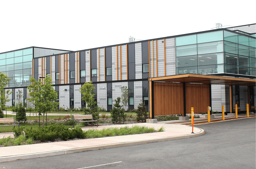 Bayers Lake Outpatient Center: Modernes zweistöckiges medizinisches Zentrum mit Glasfassade und Holzverkleidung am Eingang, umgeben von Grünflächen.