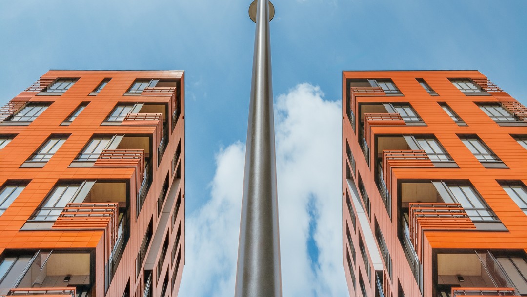 DOKI Living mit glatter Tonality Keramikfassade in Ziegelrot und Hellrot.